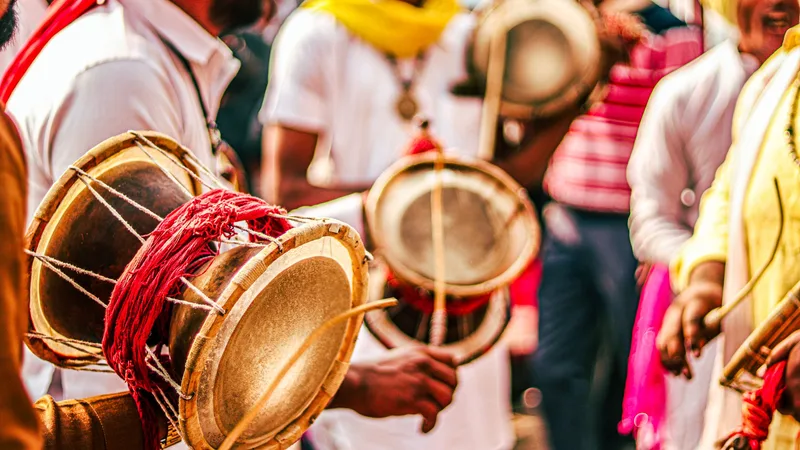 Drummers in bright colours playing large drums at an outdoor festival